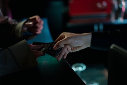 Mãos trocando ingressos de cinema em um ambiente interno.