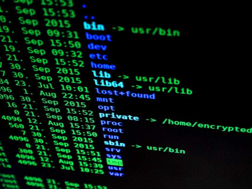 Tela de computador exibindo linhas de código coloridas, em referência a comandos ocultos e segurança digital.