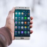 Pessoa segura um smartphone com um aplicativo exibido na tela.