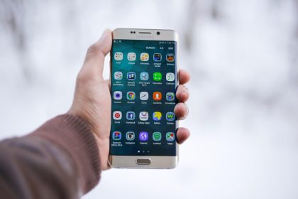 Pessoa segura um smartphone com um aplicativo exibido na tela.