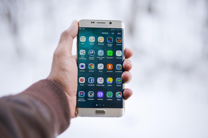 Pessoa segura um smartphone com um aplicativo exibido na tela.